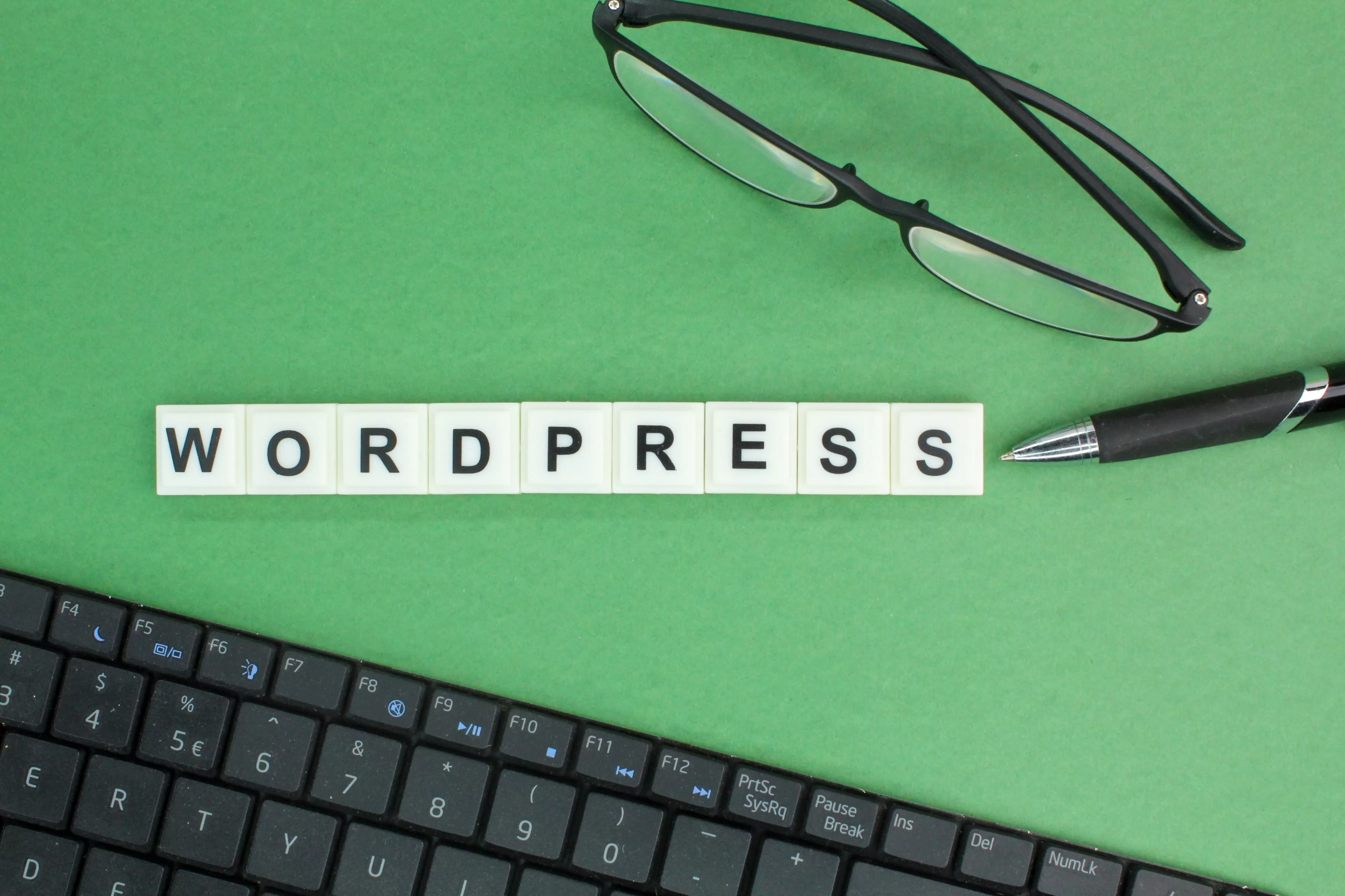 laptop-keyboard-glasses-pen-with-wordpress-alphabet-words-wordpress-concept-min